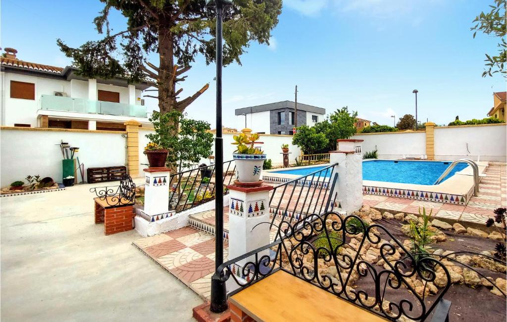 a house with a swimming pool and a fence at Nice Home In El Ventorrillo With Outdoor Swimming Pool, Wifi And Private Swimming Pool in Belicena
