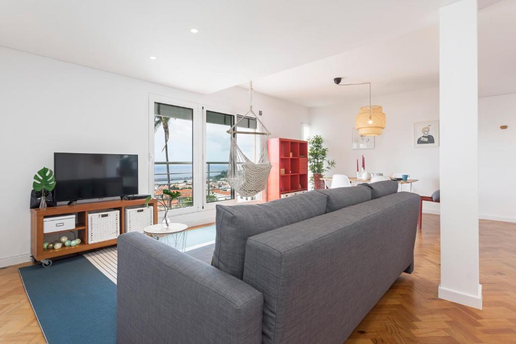 a living room with a couch and a television at Pina I by An Island Apart in Funchal