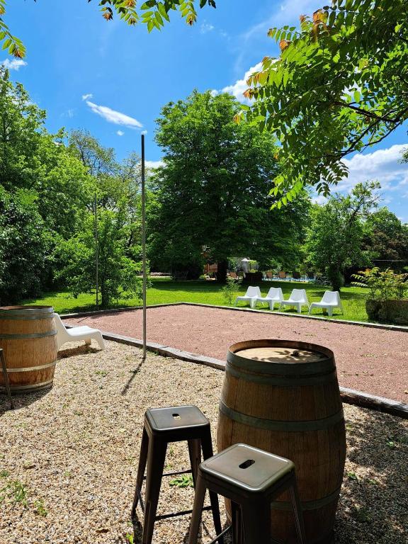 a couple of stools and a barrel with a table and chairs at NAMASTE COTTAGE in Issigeac