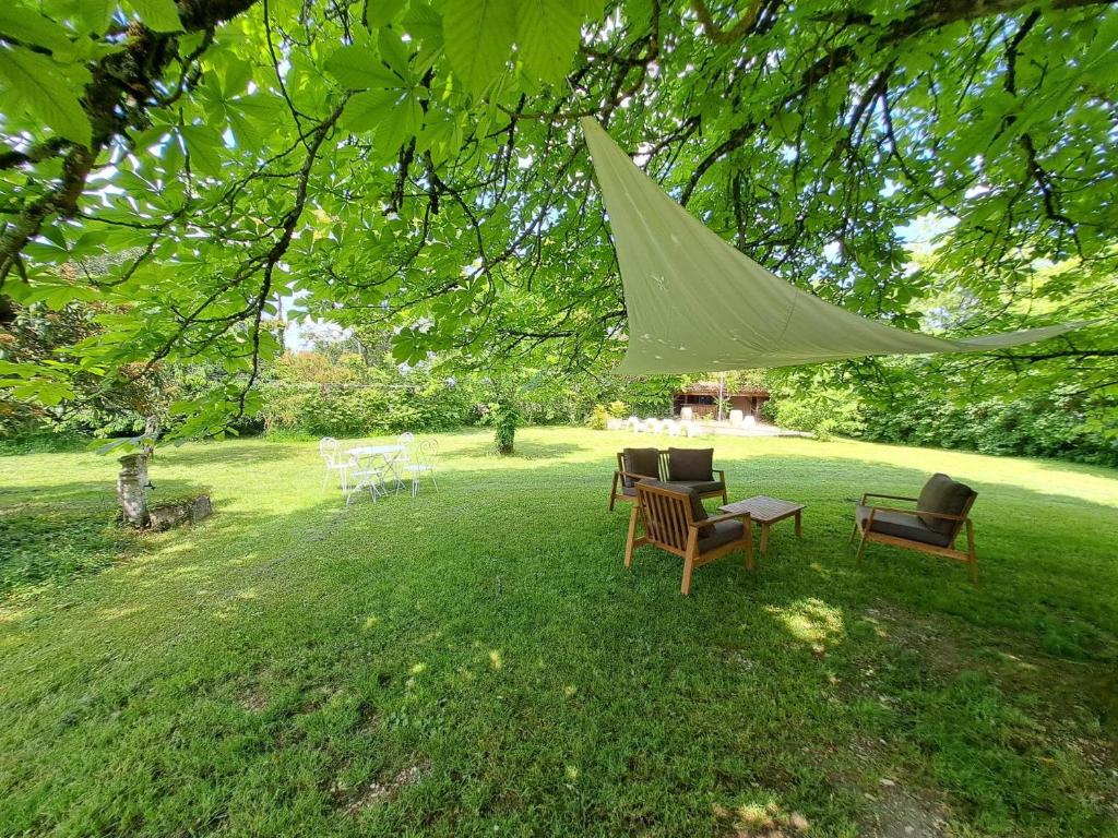 a group of chairs sitting under a tree at NAMASTE COTTAGE in Issigeac