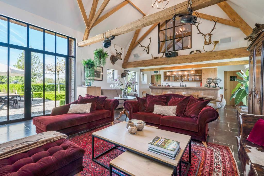 una sala de estar con sofás rojos y una mesa. en Hoeve De Zuidhoek en Bruges