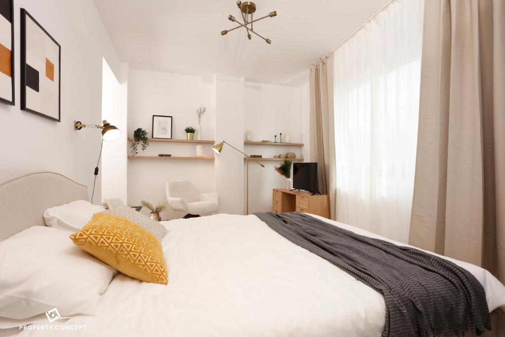 a bedroom with a white bed and a window at Chic Concept Studio in Bucharest
