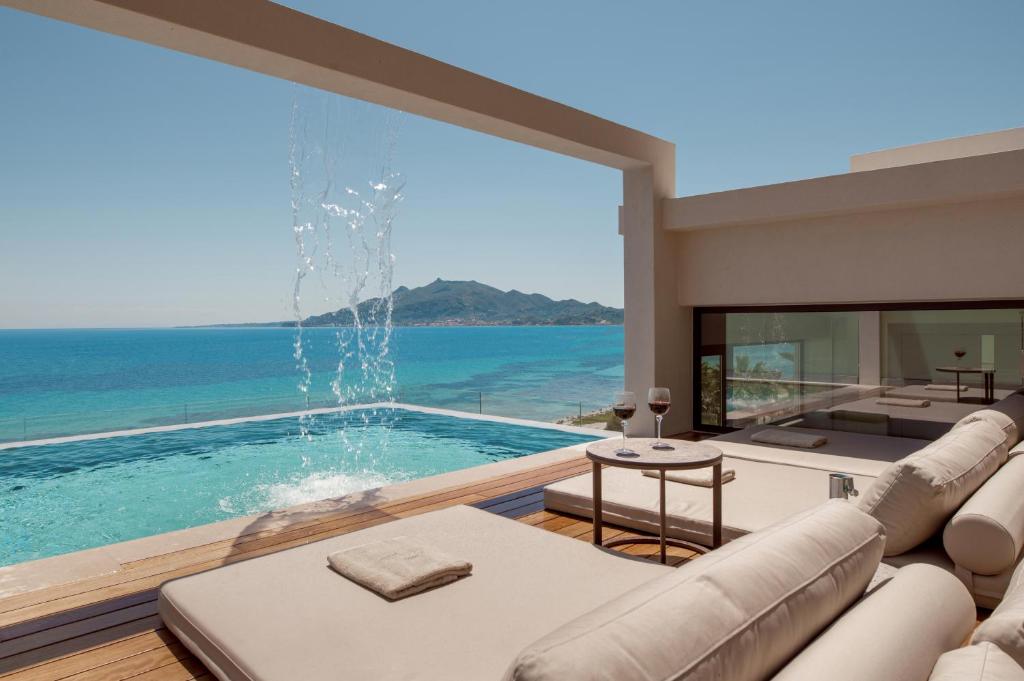 a living room with a large window and a swimming pool at Nerea Deluxe SeaFront Villa, Iconic Infinity Pool, By ThinkVilla in Zakynthos