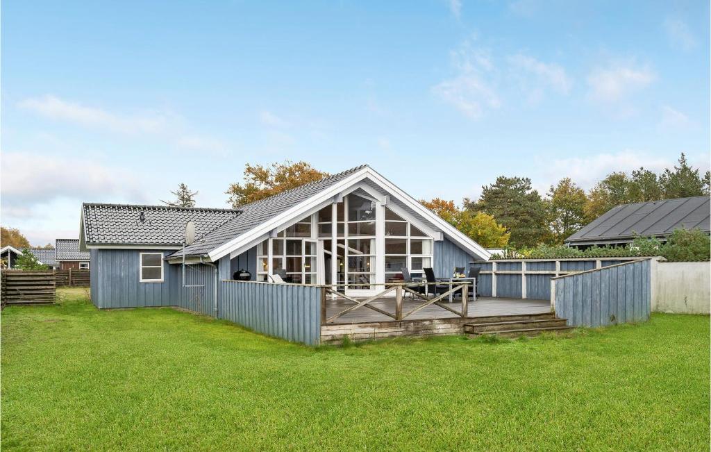 ein blaues Haus mit einem großen Glasfenster in der Unterkunft Pet Friendly Home In Grlev With Kitchen in Reersø