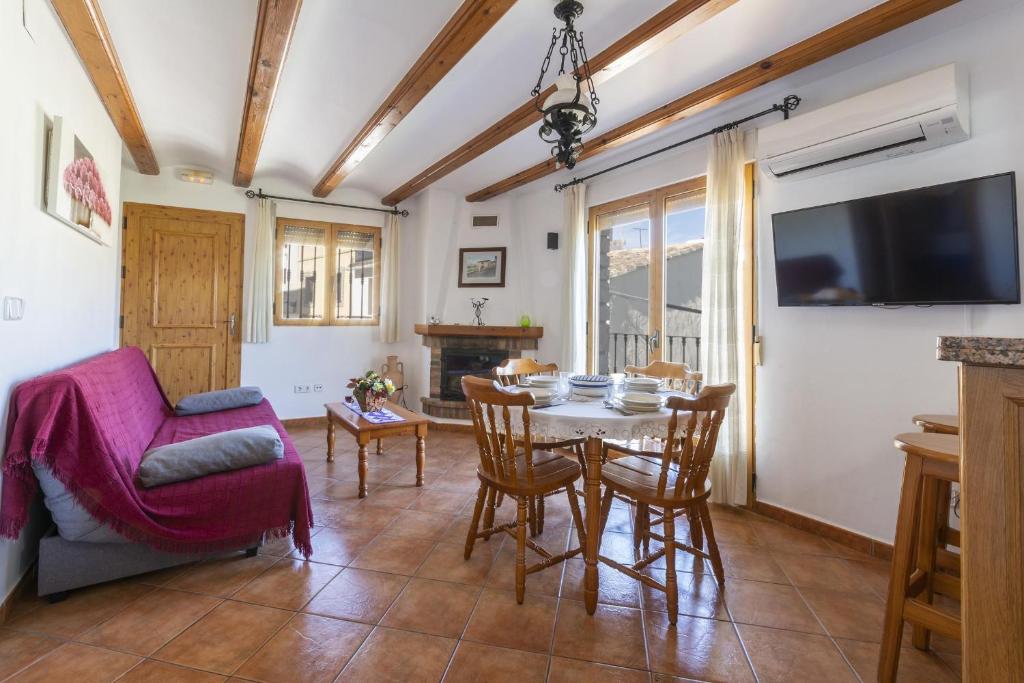 ein Wohnzimmer mit einem Tisch und Stühlen sowie einem TV in der Unterkunft Carrebaix I in Orba