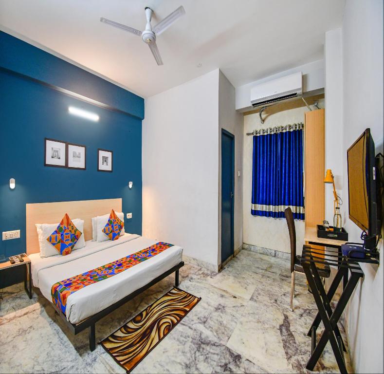 FabHotel Silverkey Kalighat في كولْكاتا: غرفة نوم مع سرير مزدوج كبير ومكتب
