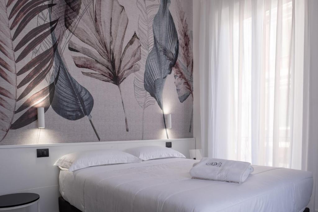- une chambre avec un lit blanc orné d'une peinture murale dans l'établissement Domea Superior Rooms Bed and Breakfast, à Reggio de Calabre