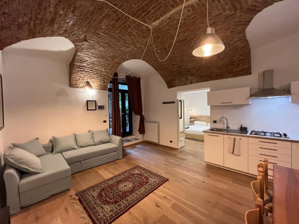 Suite The Brick في تورينو: غرفة معيشة مع أريكة ومطبخ