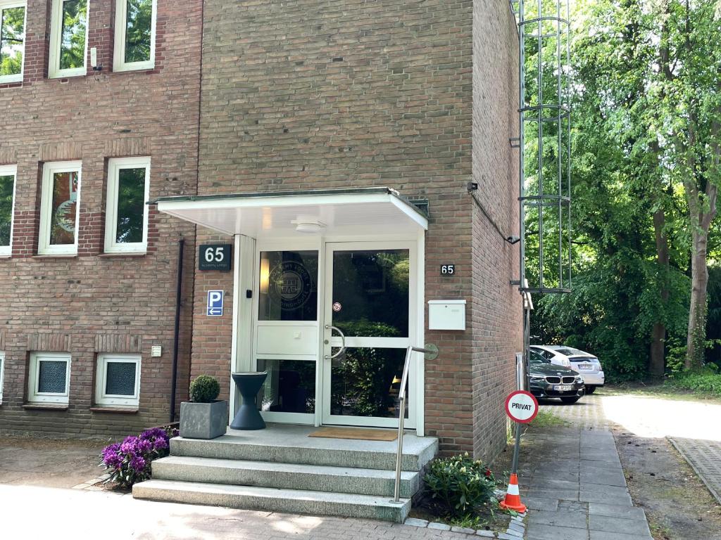 una entrada a un edificio de ladrillo con una puerta blanca en Academy Lodge Boardinghouse, en Hamburgo