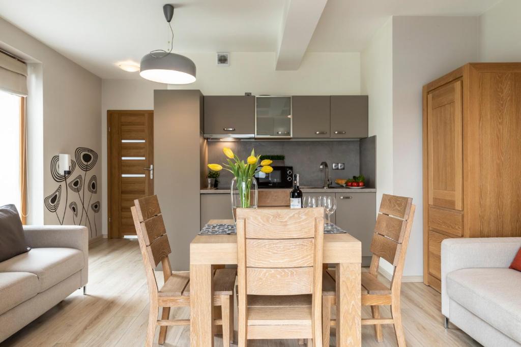 a kitchen and dining room with a table and chairs at udanypobyt Apartamenty Smrekowa in Zakopane