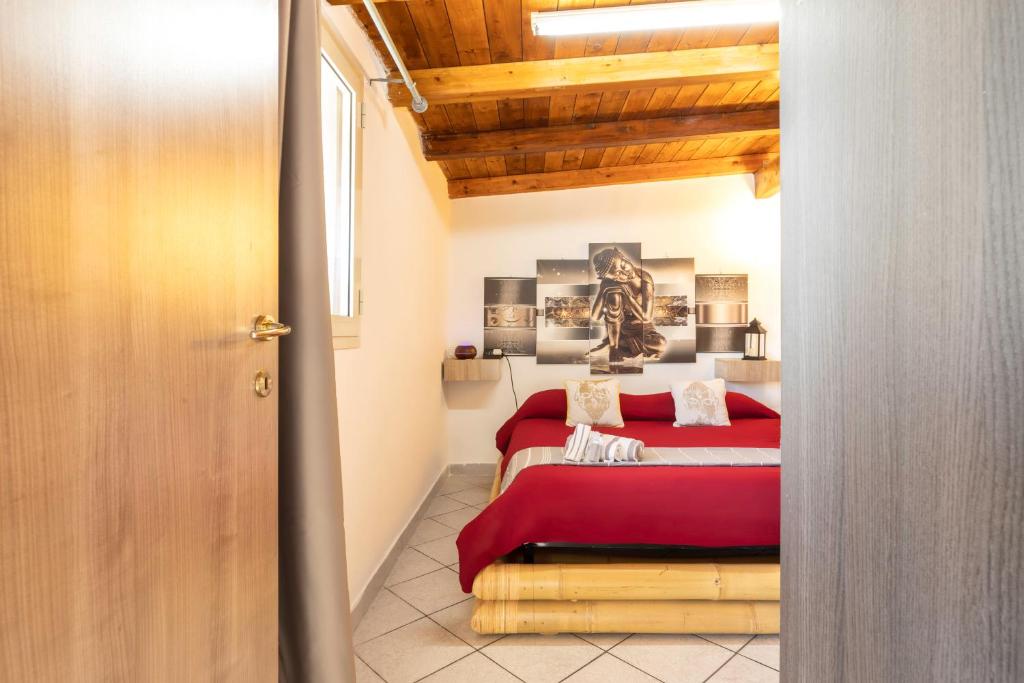 薩薩里的住宿－Posizione strategica, Wi-Fi e parcheggio gratuito，一间卧室设有红色的床和木制天花板。