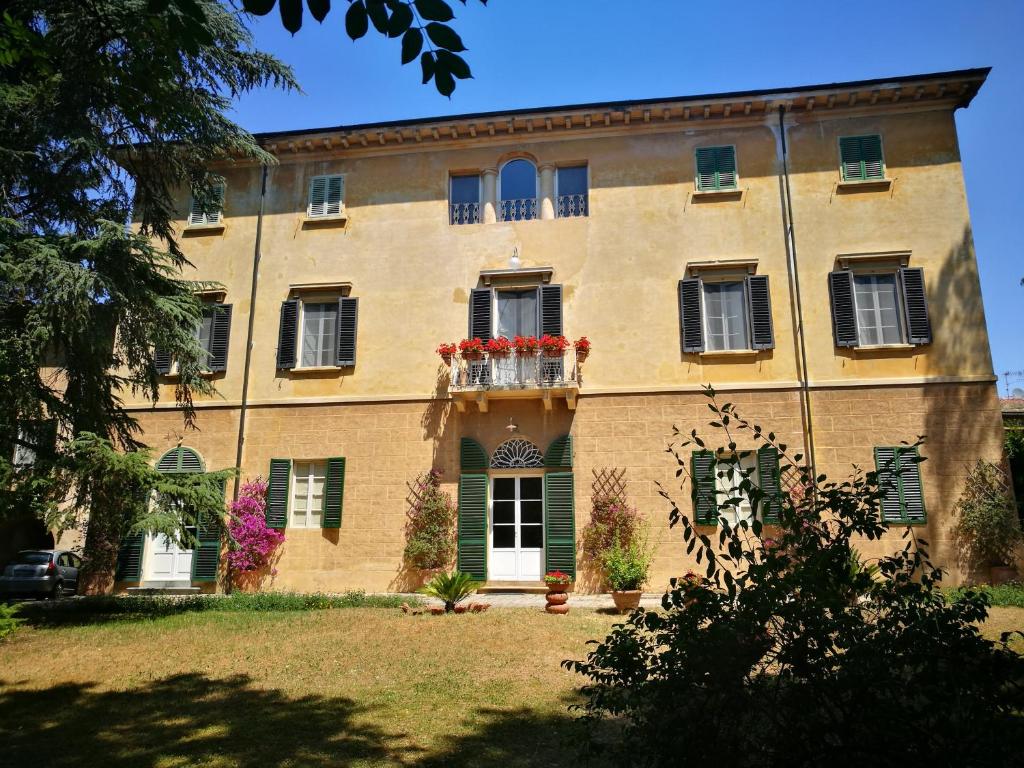 - un grand bâtiment en briques avec des fleurs sur un balcon dans l'établissement Il mondo di Giada, à Vicopisano