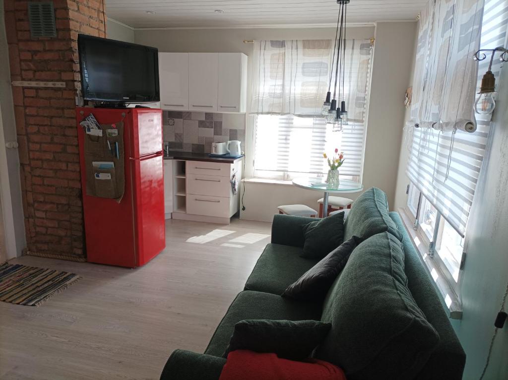 a living room with a couch and a red refrigerator at Oakcorner Place Apartment in Haapsalu