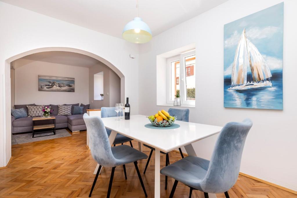 een eetkamer met een witte tafel en stoelen bij J&T - app J&T in Mali Lošinj