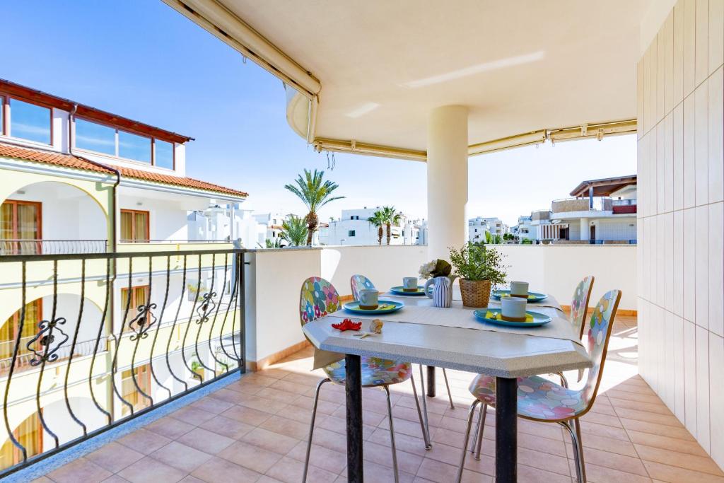 eine Terrasse mit einem Tisch und Stühlen auf dem Balkon in der Unterkunft Appartamento Margherita Plus - MyHo Casa in Vieste