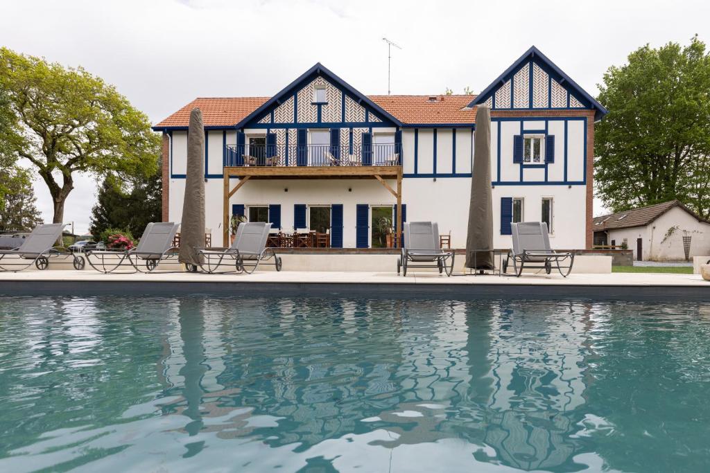 una casa con piscina frente a una casa en Domaine Baruteau, en Soustons