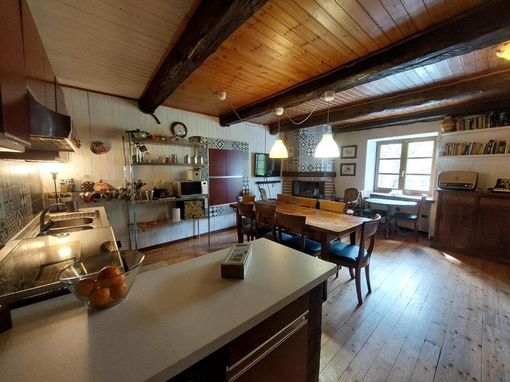 a large kitchen with a table and a dining room at casa Fiorella in Mattie