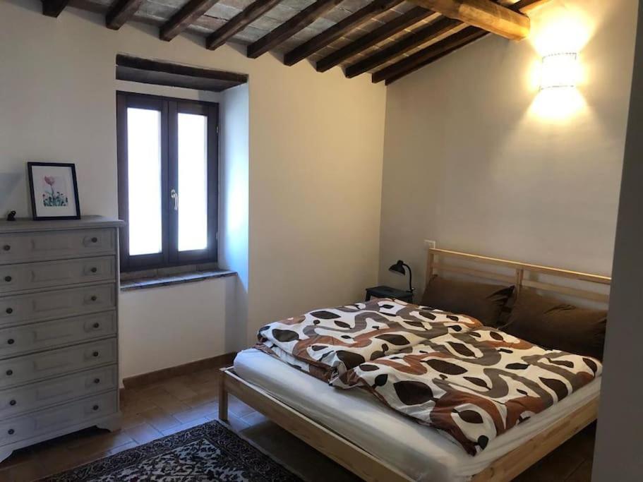 ein Schlafzimmer mit einem Bett, einer Kommode und einem Fenster in der Unterkunft La casetta in Ferentillo