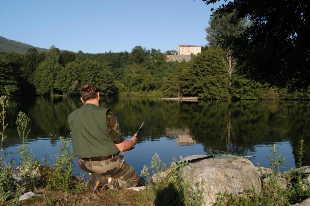 a man holding a fishing rod on a lake at mobil-home du lac de Foix in Foix