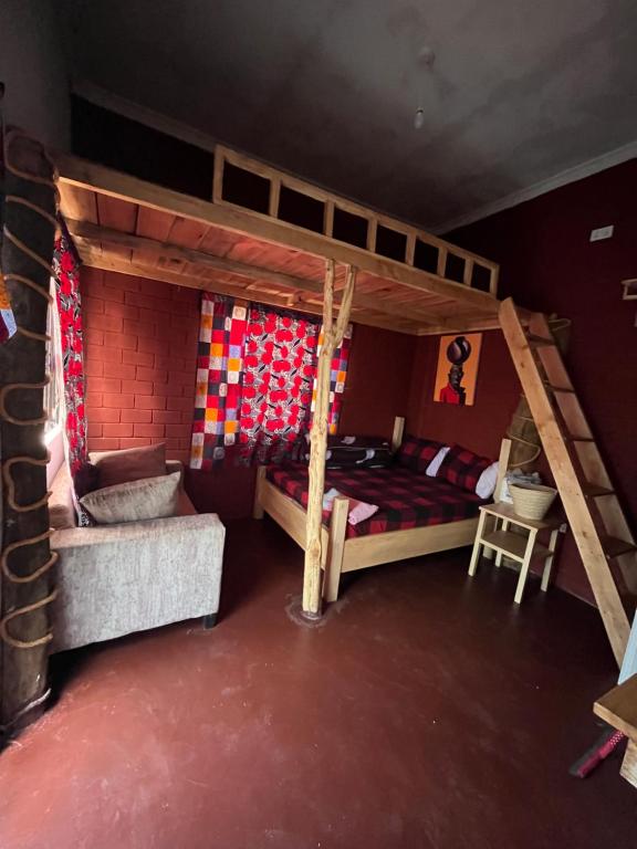 Meleji studio room في أروشا: غرفة نوم مع سريرين بطابقين وأريكة