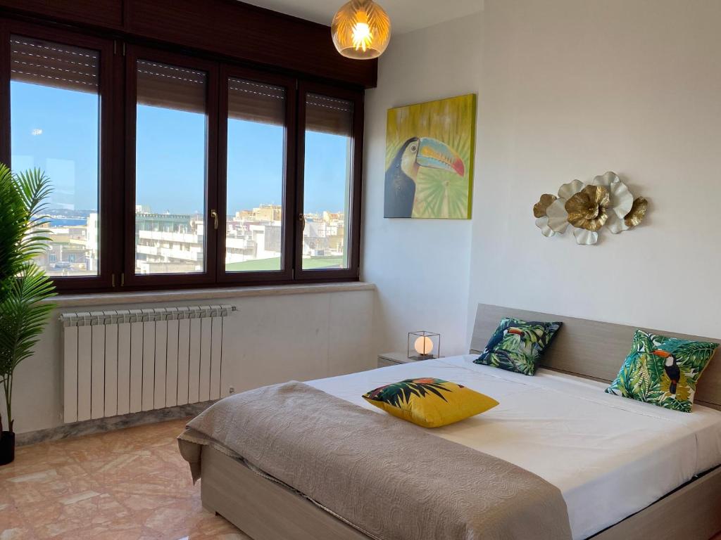 ein Schlafzimmer mit einem Bett in einem Zimmer mit Fenstern in der Unterkunft Tropical Apartment in Gallipoli