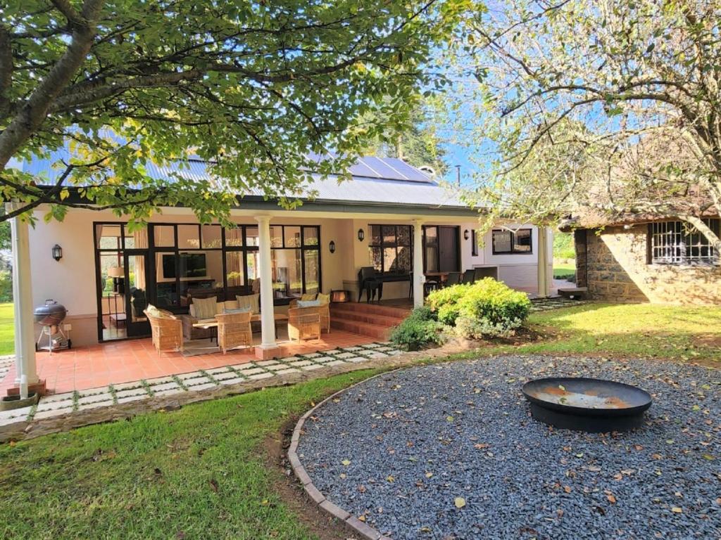 une maison avec une terrasse couverte et un patio dans l'établissement Hydrangea Guest House, à Nottingham Road