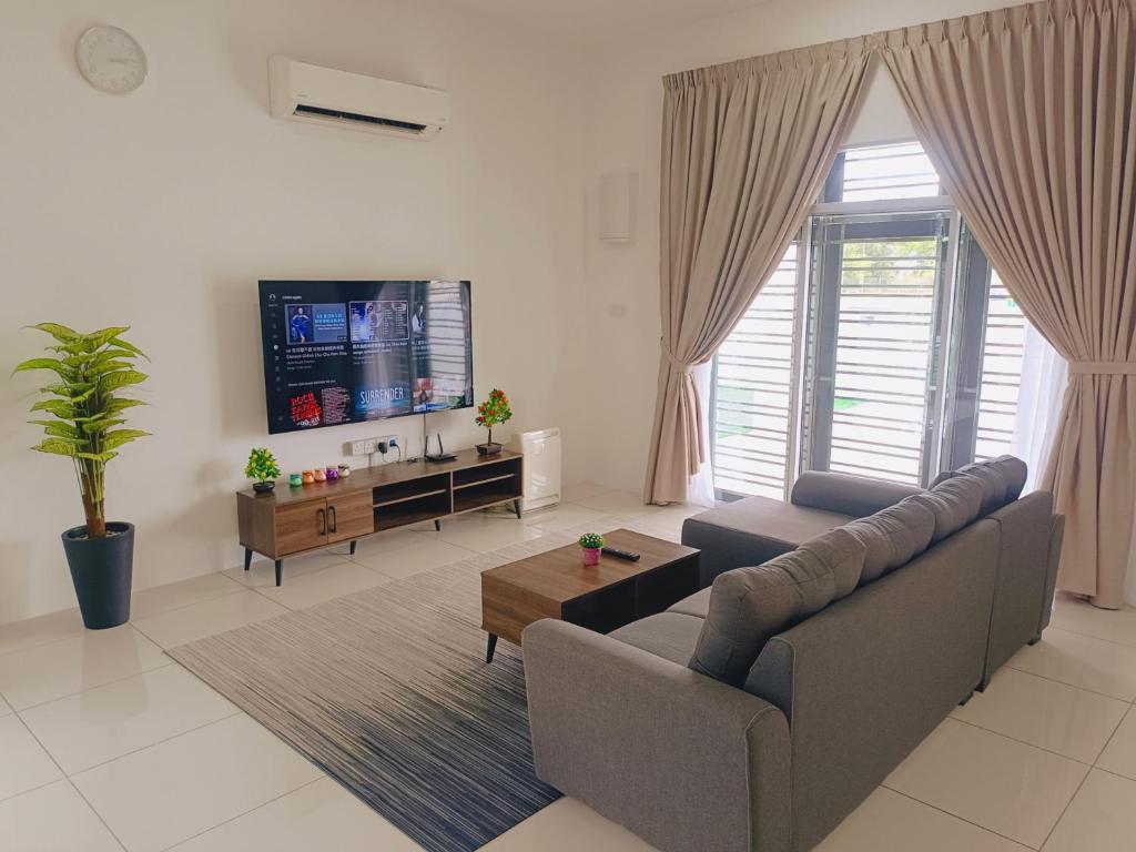 a living room with a couch and a flat screen tv at Yarra Park, Up to 10 Pax, 5 Bedrooms, 4 Bathrooms, 2 Car Parks by Star Home in Sungai Petani