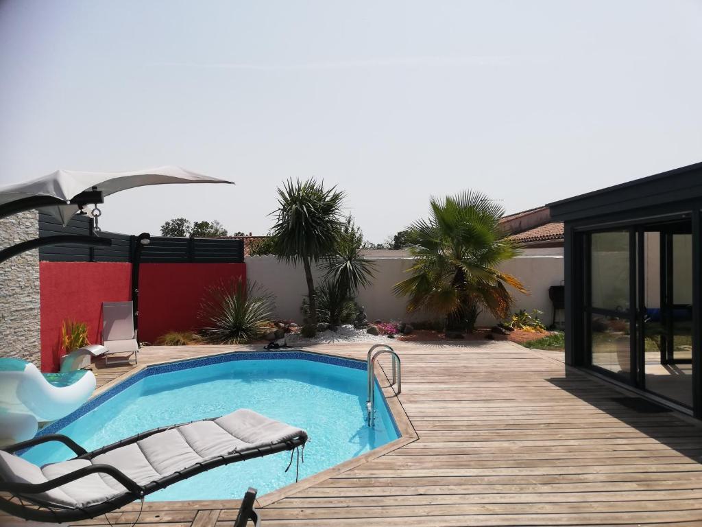 - une piscine avec une chaise et une terrasse dans l'établissement Studio indépendant chez l'habitant avec piscine et cuisine extérieure, à La Rochelle