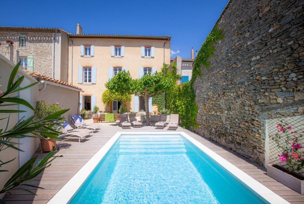 a swimming pool in front of a building at La Chasse au Bonheur in Rieux-Minervois
