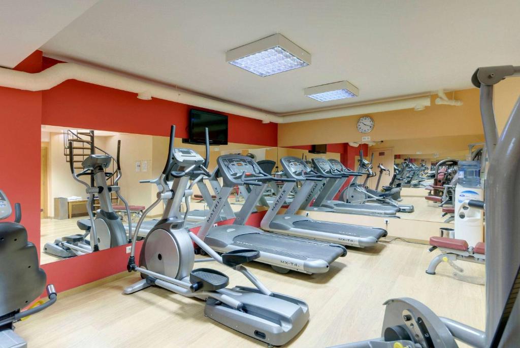a gym with rows of treadmills and elliptical machines at TRYP by Wyndham Porto Expo Hotel in Leça da Palmeira