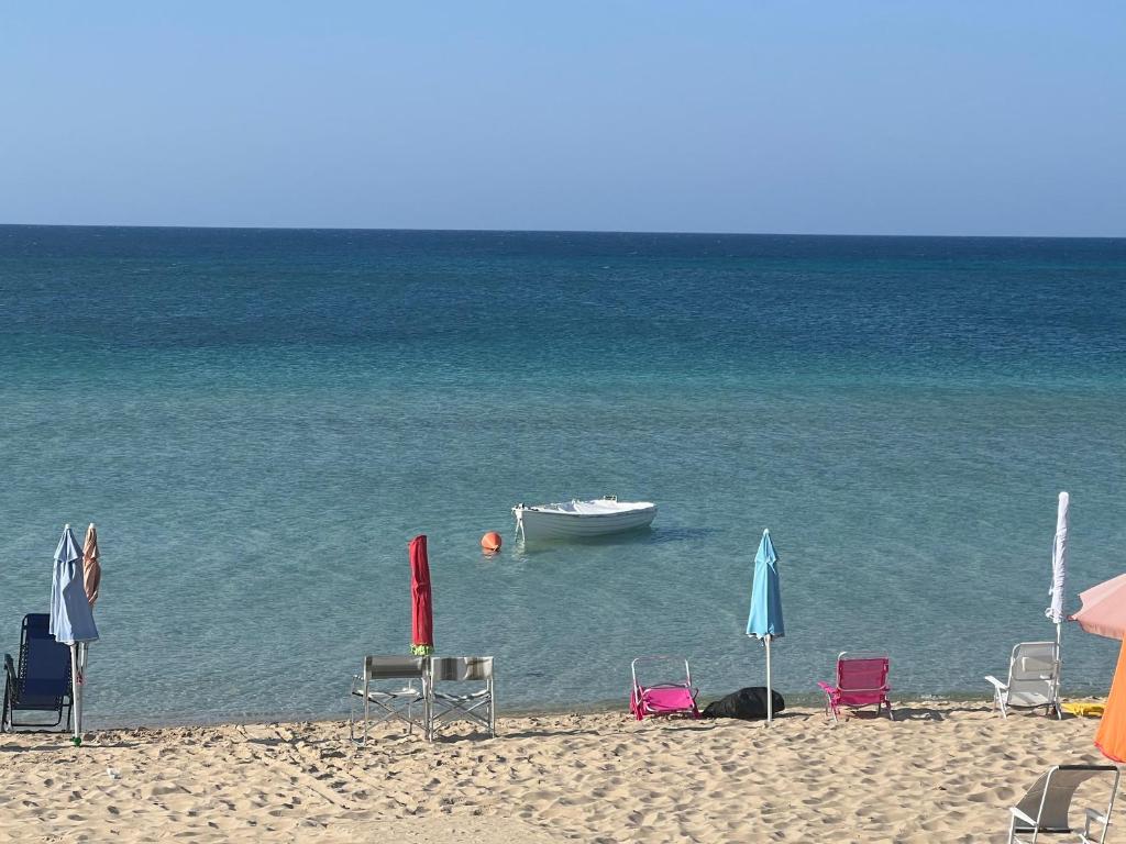 plaża z leżakami i łódź w wodzie w obiekcie A due passi sul mare w mieście San Pietro in Bevagna