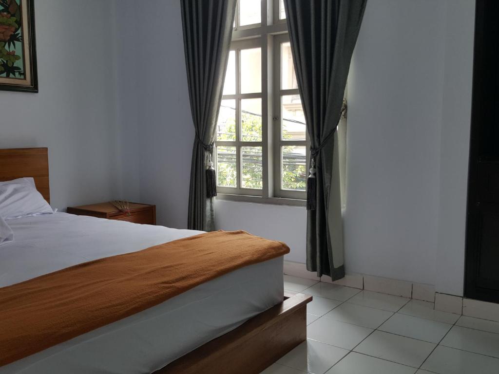 ein Schlafzimmer mit einem Bett und einem großen Fenster in der Unterkunft C4 homestay in Jakarta