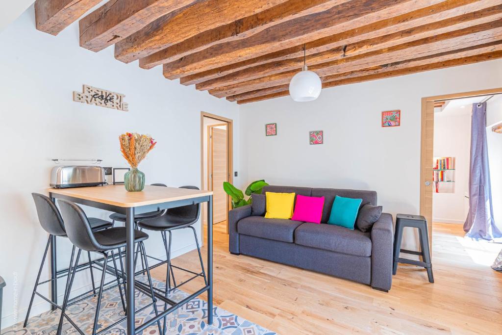 a living room with a couch and a table at Le Petit Rex in Paris