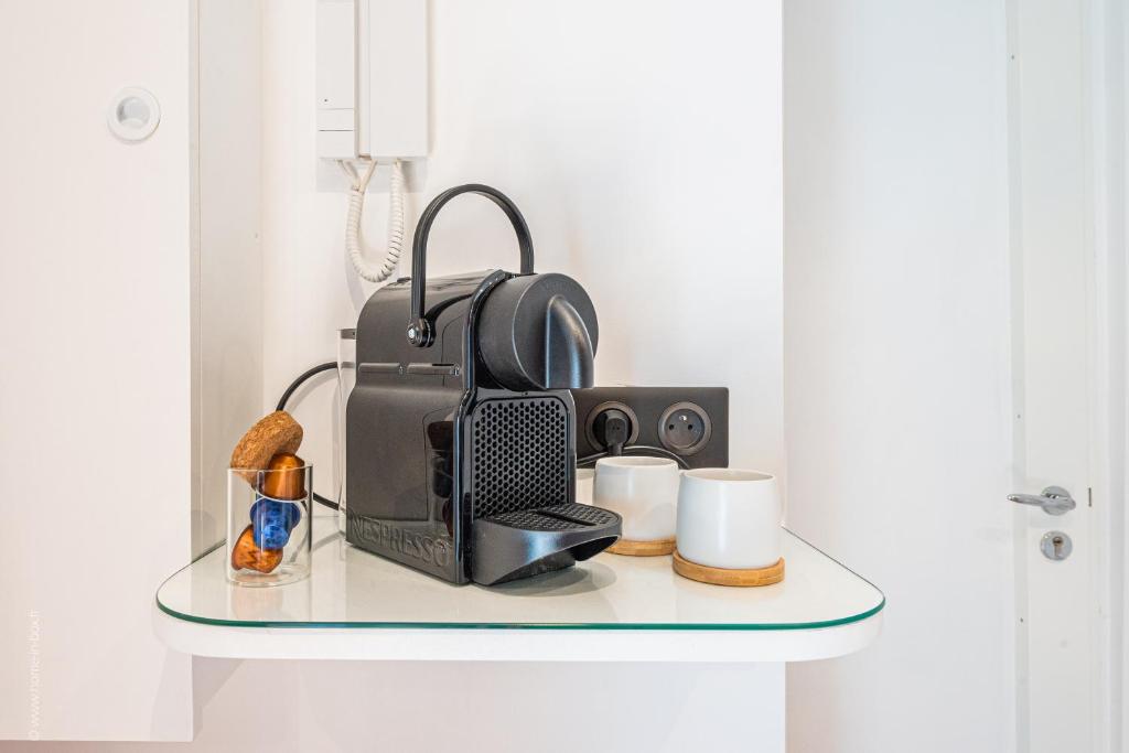 a glass shelf with a microwave and a radio on it at Le Petit Rex in Paris