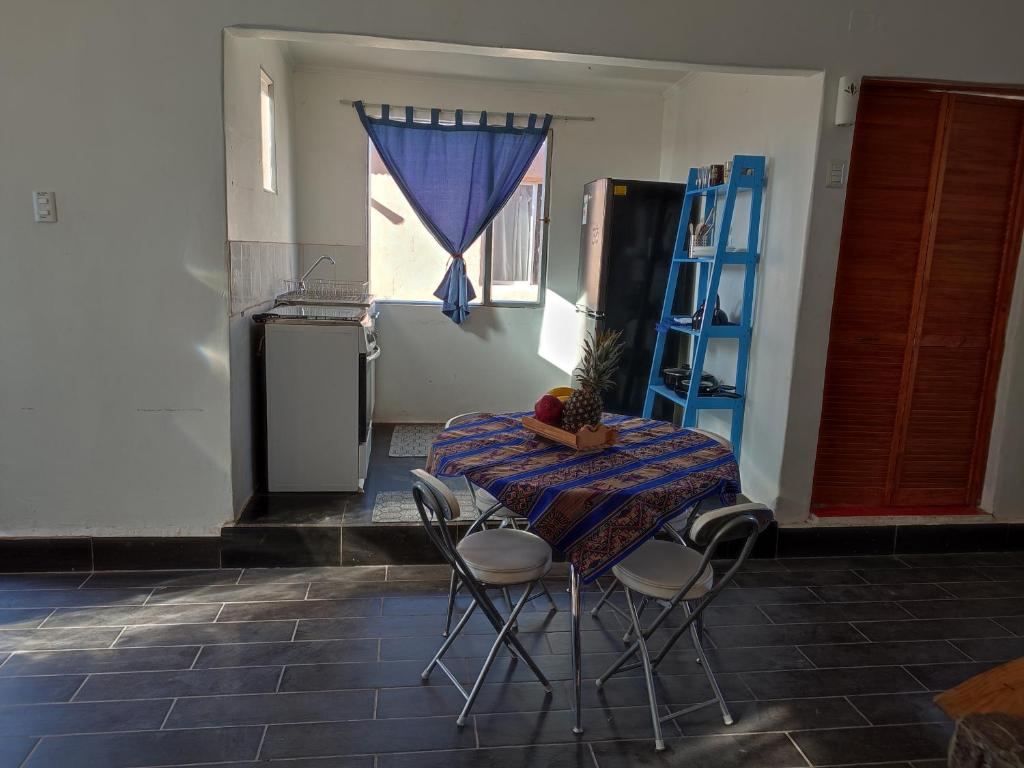 einen Tisch und Stühle in einem Zimmer mit Fenster in der Unterkunft Cabañas Rica-Rica Lodge in San Pedro de Atacama