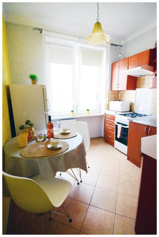 a kitchen with a table and chairs in a kitchen at Color24 Apartament VI in Stalowa Wola