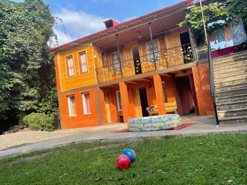 ein Haus mit einem Ball im Gras davor in der Unterkunft NIKATOLO - HOTEL GUESTHOUSE 