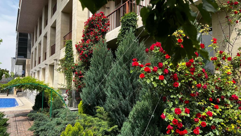 Olympia Garden Hotel في يريفان: حديقة من الزهور أمام المبنى