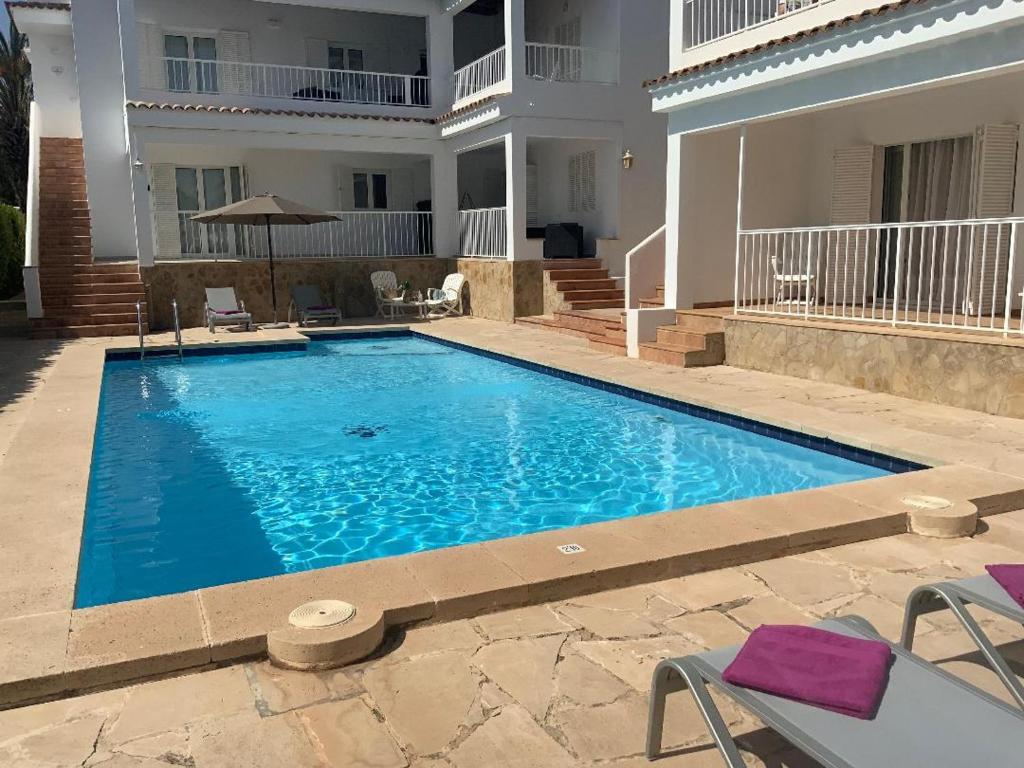 een groot blauw zwembad voor een huis bij Aptos dOr in Cala d´Or