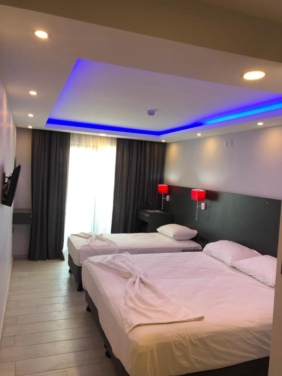 ein Hotelzimmer mit 3 Betten und blauem Licht in der Unterkunft Erikli suit home in Erikli