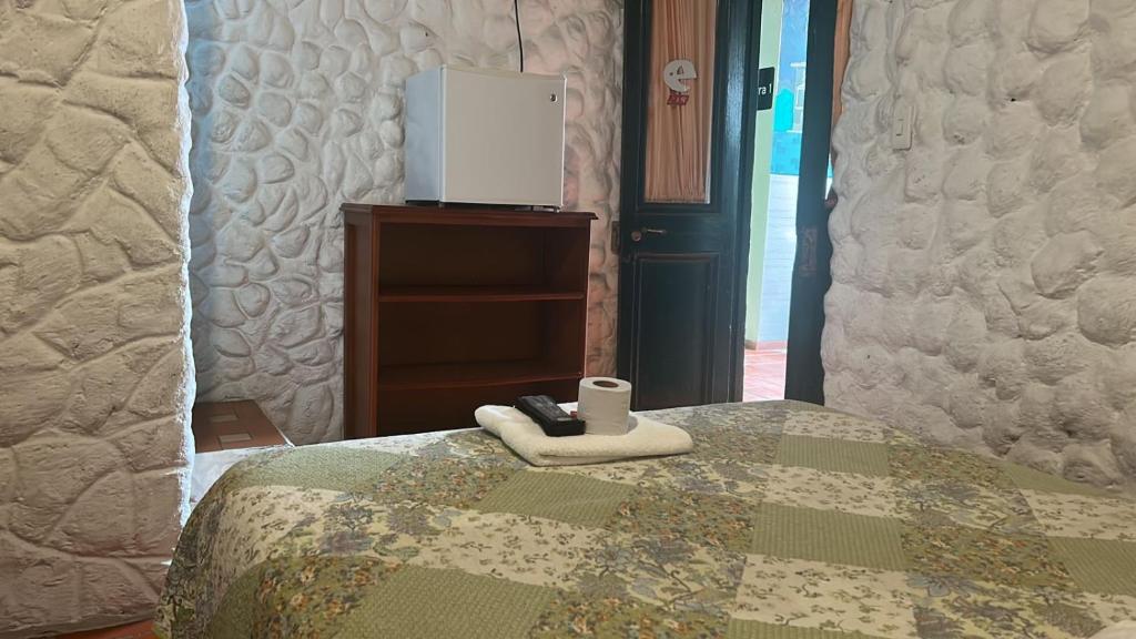 Dorado Plaza في زيباكويرا: غرفة نوم مع سرير مع ريموت كنترول عليه