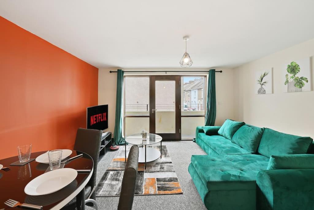 a living room with a green couch and a table at City Centre, Free Wifi & Netflix in Kent