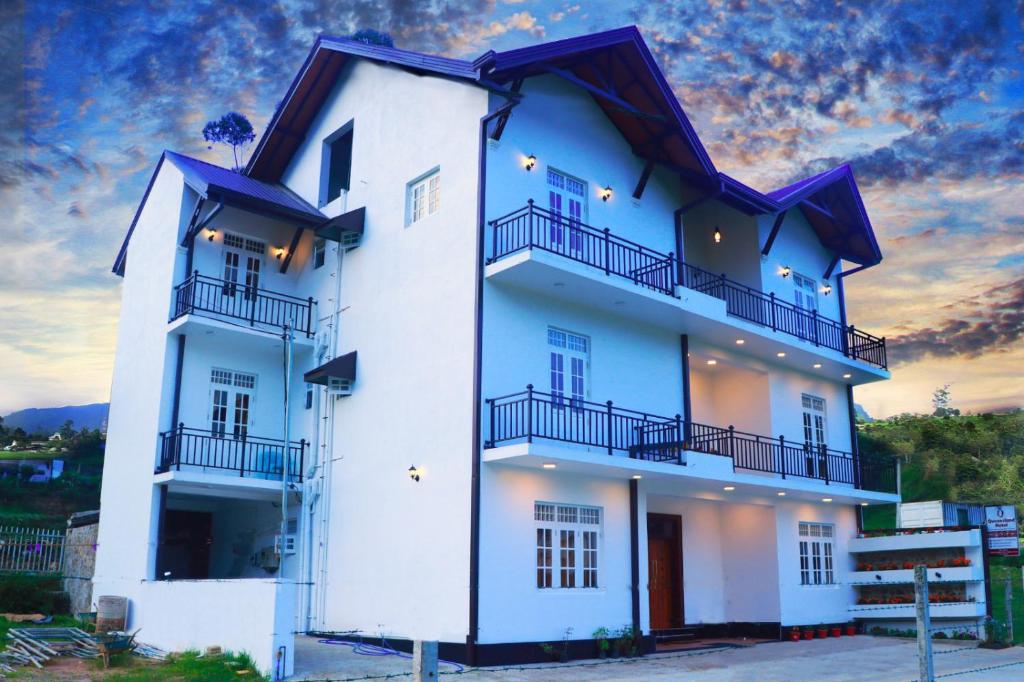 un edificio blanco con balcones en un lateral en Queensland Hotel en Nuwara Eliya