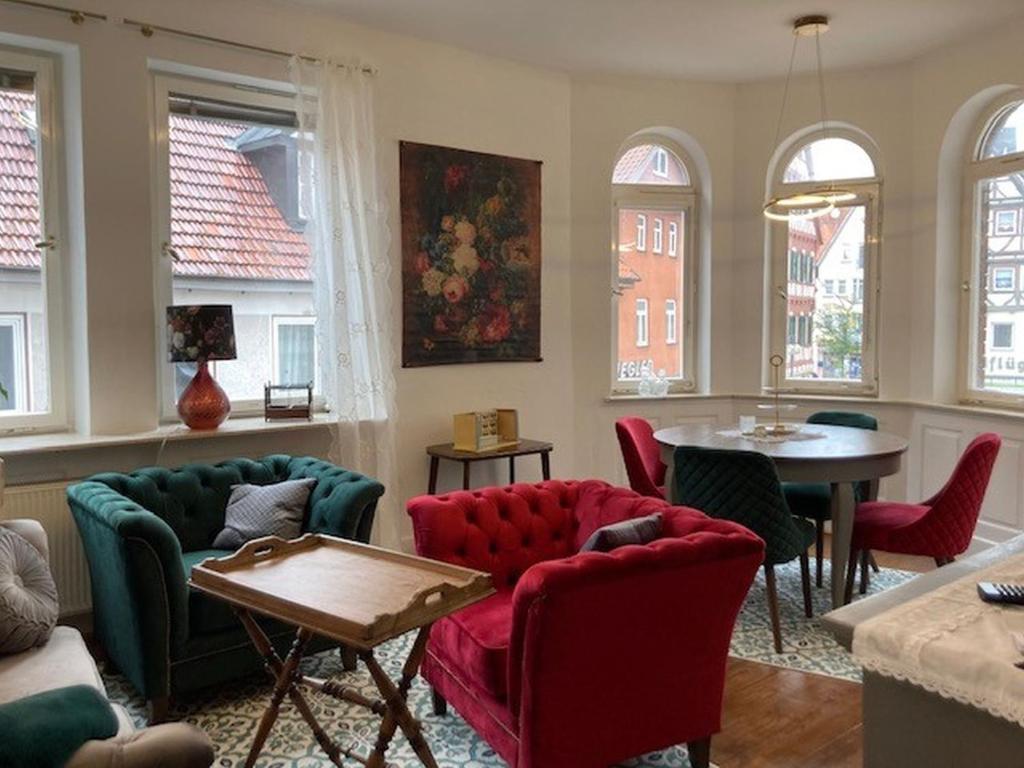 a living room with chairs and a table and windows at Ferienwohnung Luise in Münsingen