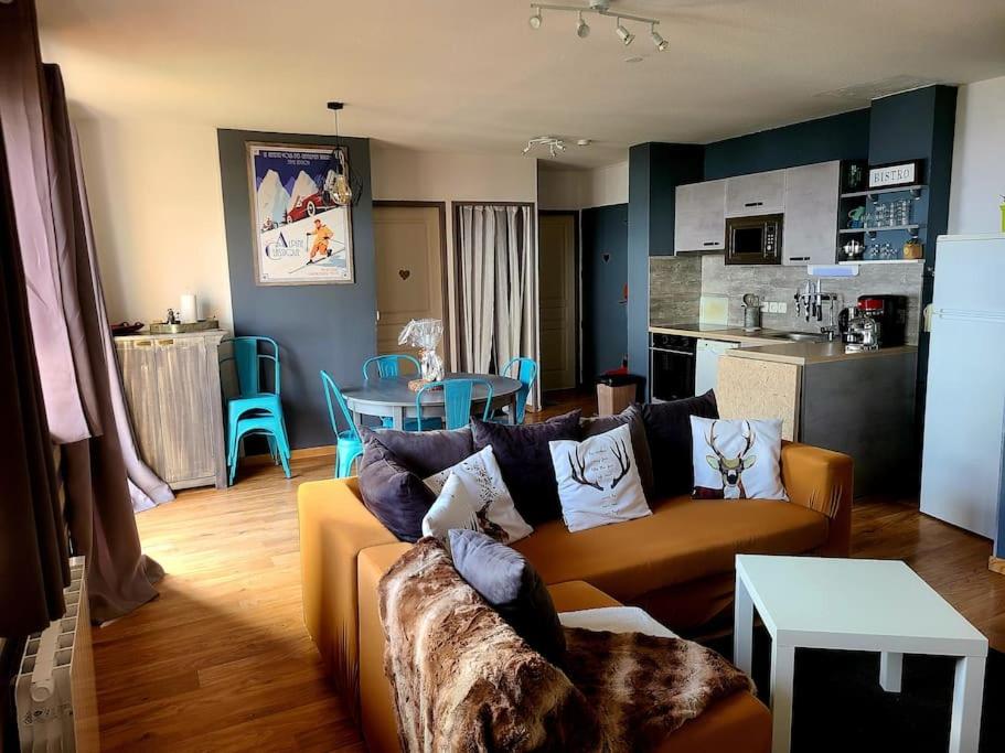 Il comprend un salon avec un canapé et une cuisine. dans l'établissement Grand appartement au pied des pistes !, à Chamrousse