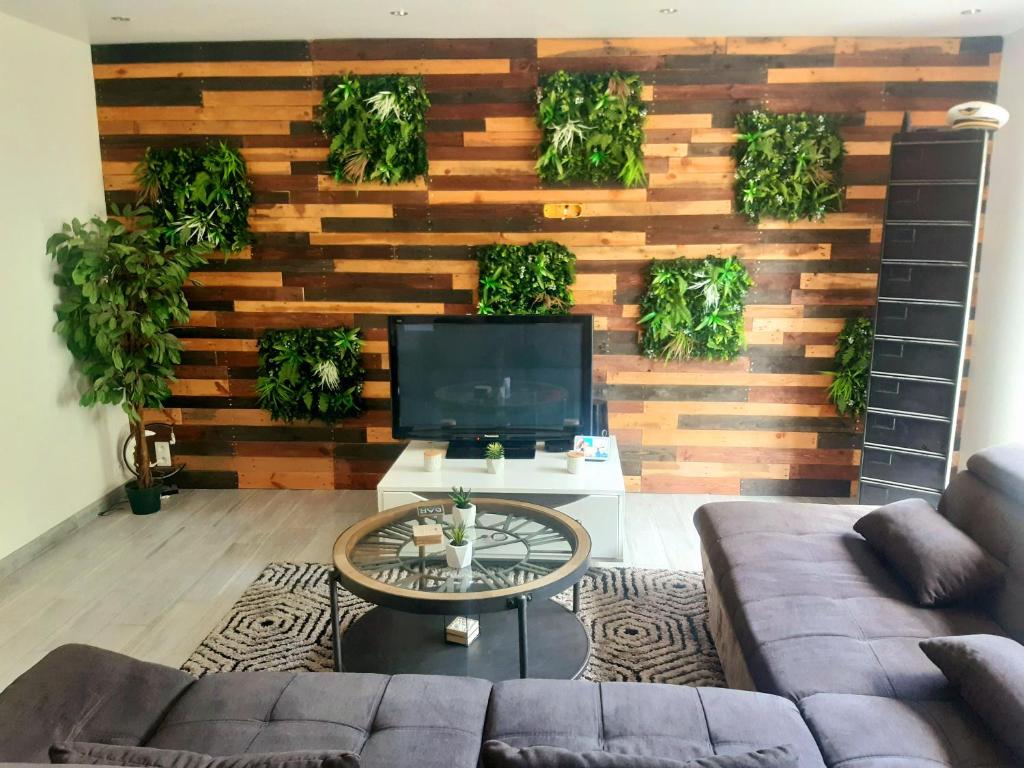 a living room with a wooden wall with plants at Chambres Privées " Les Pins " in Béziers