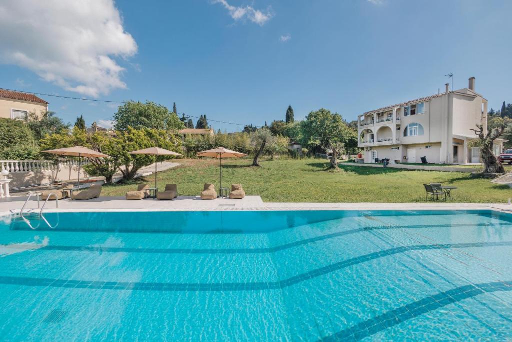 a large swimming pool in front of a house at Pelithea Family Aparthotel by Hotelius in Corfu Town