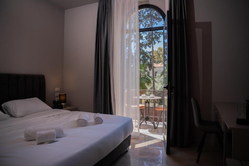 a bedroom with a bed and a desk and a window at All Seasons Boutique Hotel - Jerusalem in Jerusalem