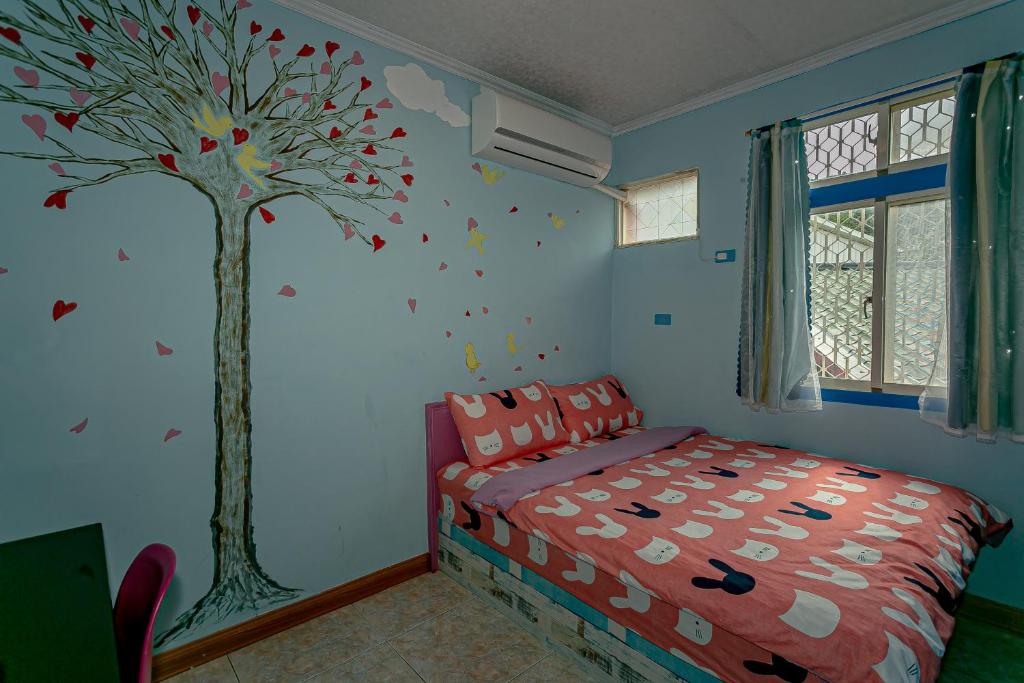 a childs bedroom with a tree painted on the wall at Evening Sun B&amp;B in Green Island