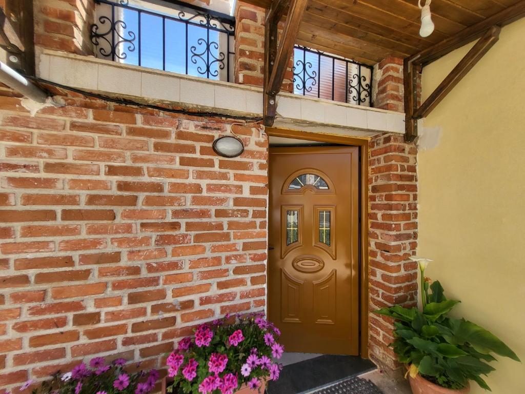 薩蘭達的住宿－Villa Sotiri，砖房,有棕色的门和鲜花